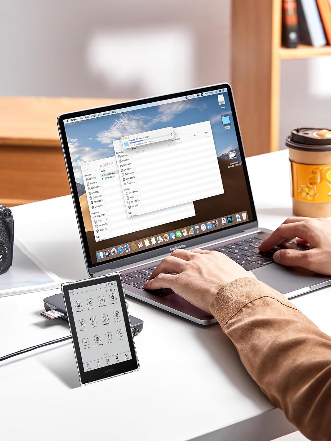 User interacting with Onyx BOOX Go 6 e-Reader in case, connected to laptop