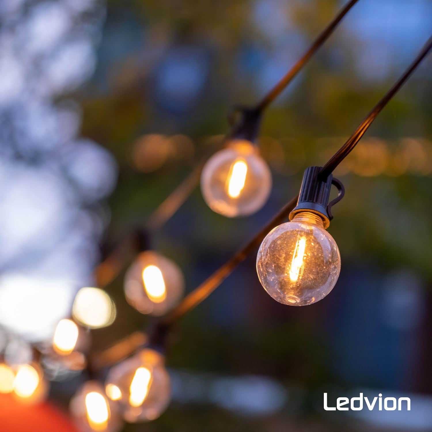 Ledvion LED string lights illuminated in an outdoor setting at dusk, creating an ambient glow.
