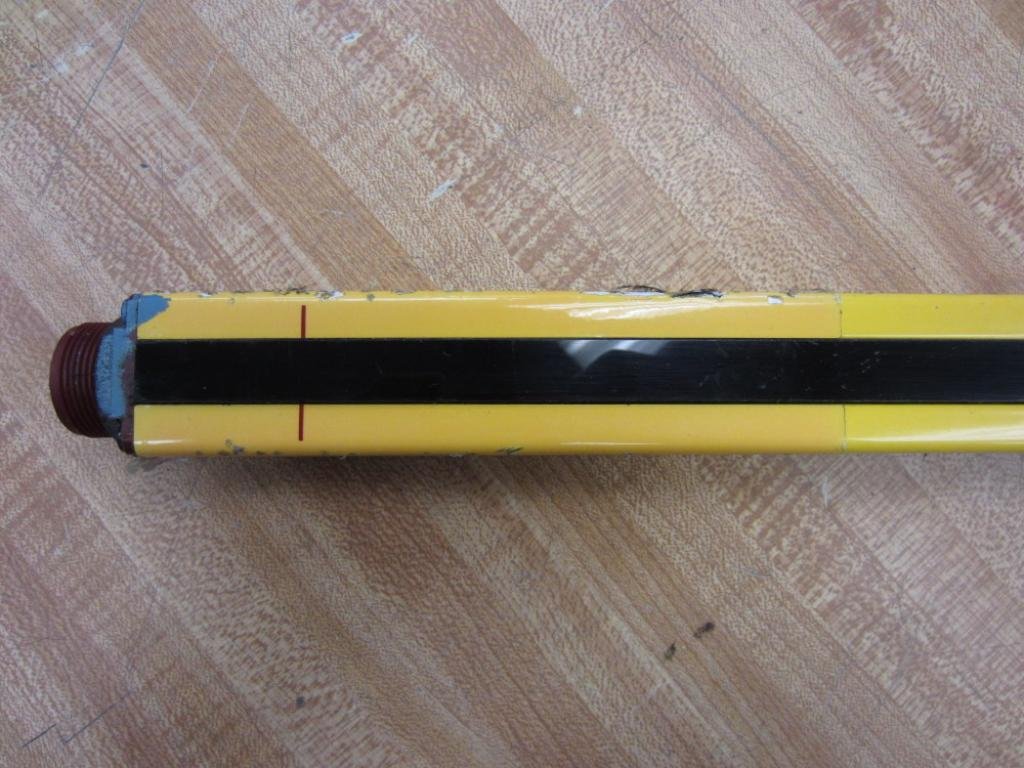 Close-up of the light curtain housing showing the black sensing strip