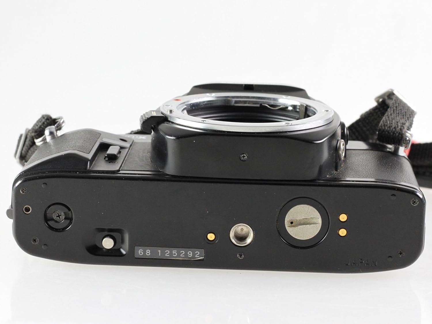 Bottom view of the Ricoh KR-10x SLR camera, showing the battery compartment and tripod mount.