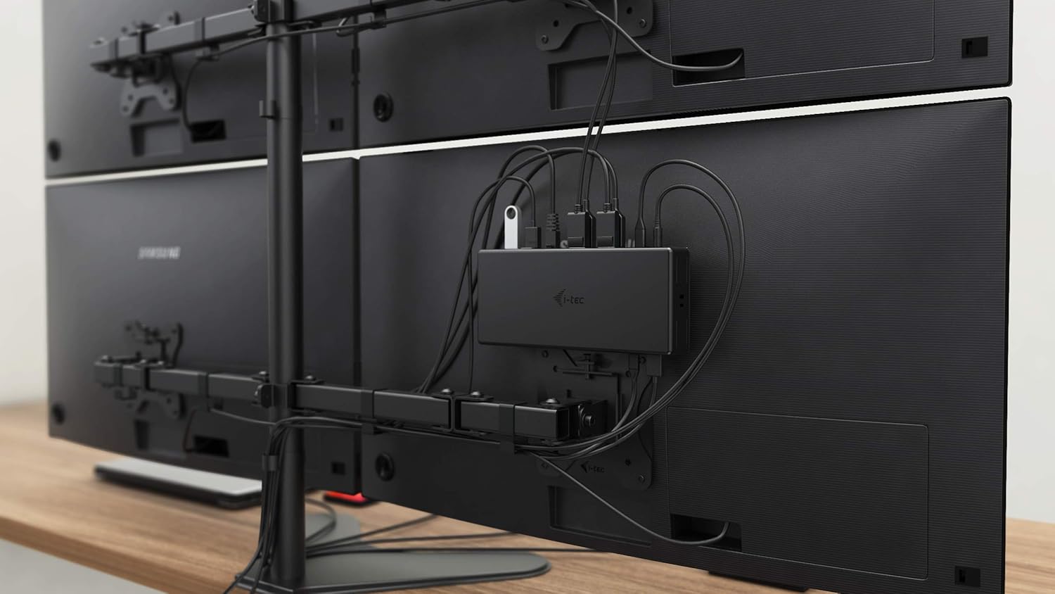 The i-tec docking station mounted on the back of a VESA compatible monitor, showing cable management.