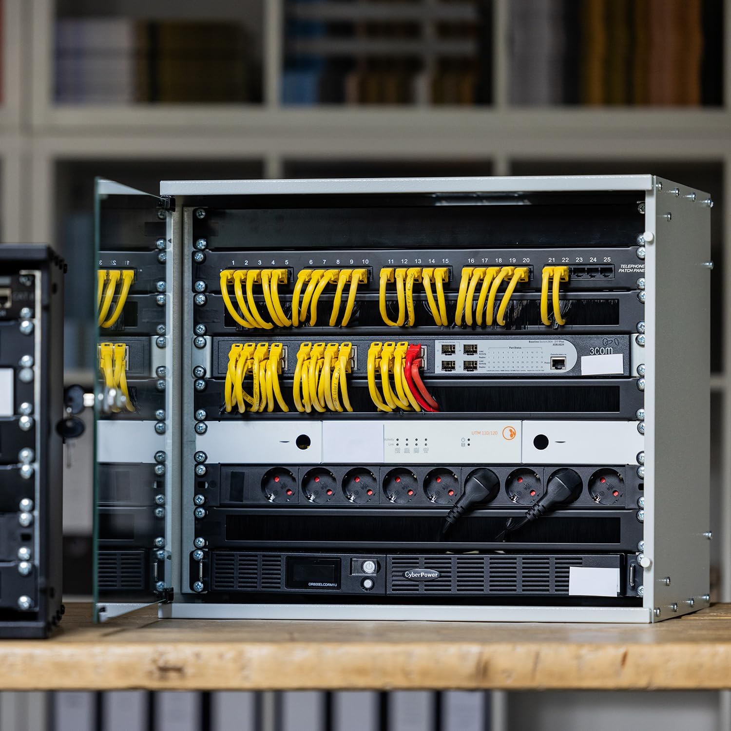 HMF 65709-02 rack cabinet with network equipment installed, showing organized cables and power strips.