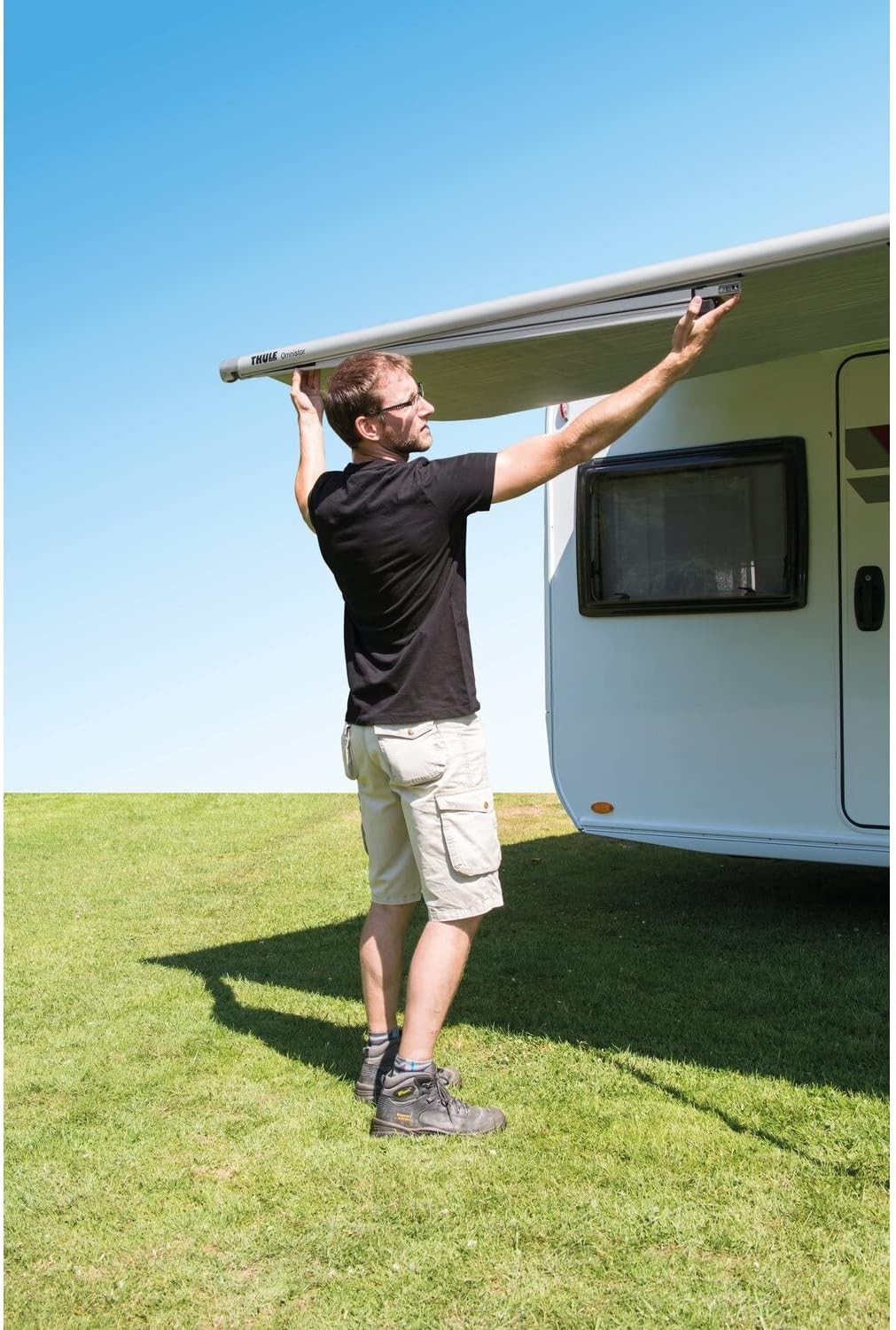 Man extending the Thule Omnistor 1200 awning from its bag