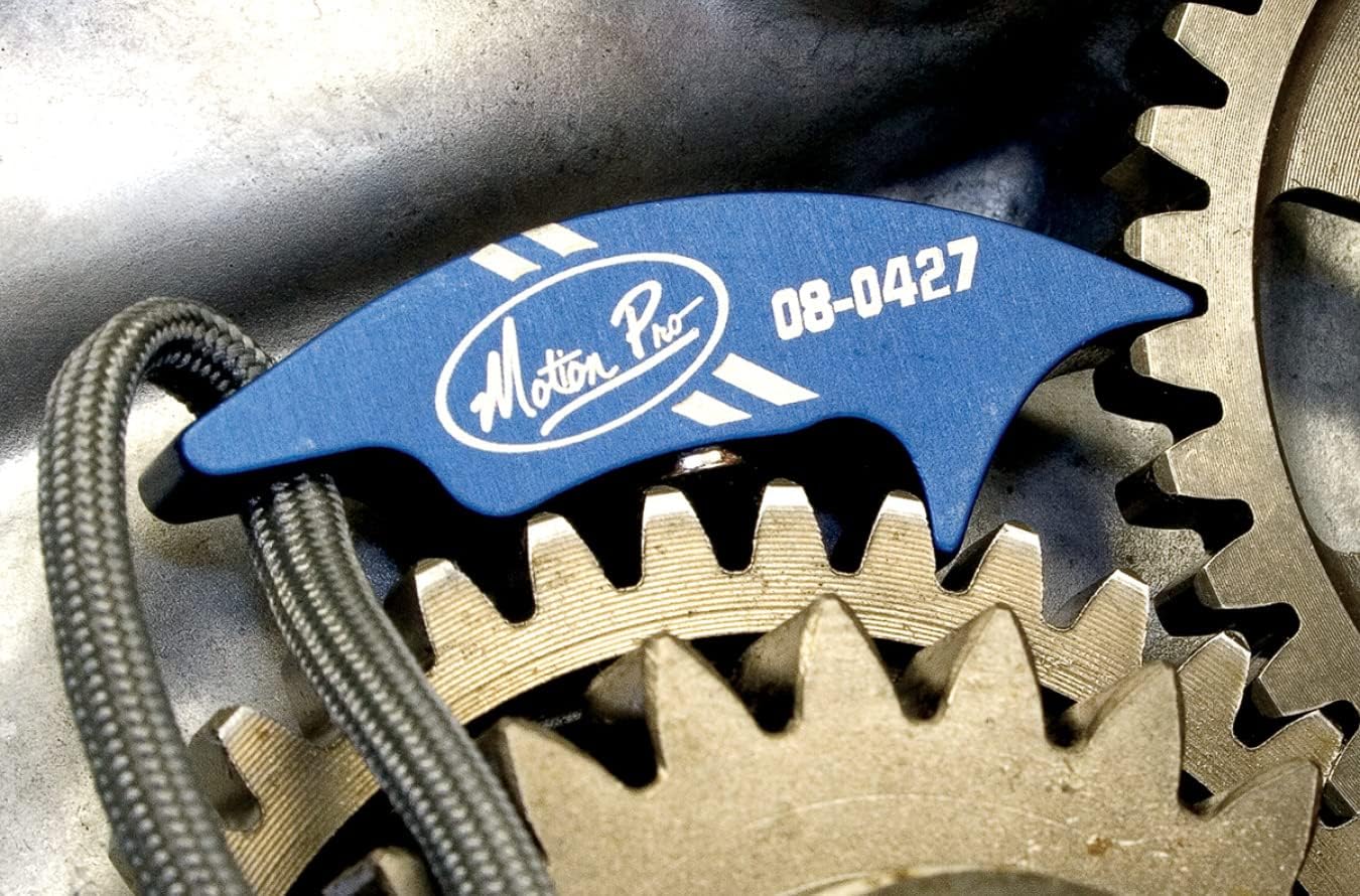 Motion Pro 08-0427 Gear Jammer Tool in use, wedged between two metal gears inside an engine casing.