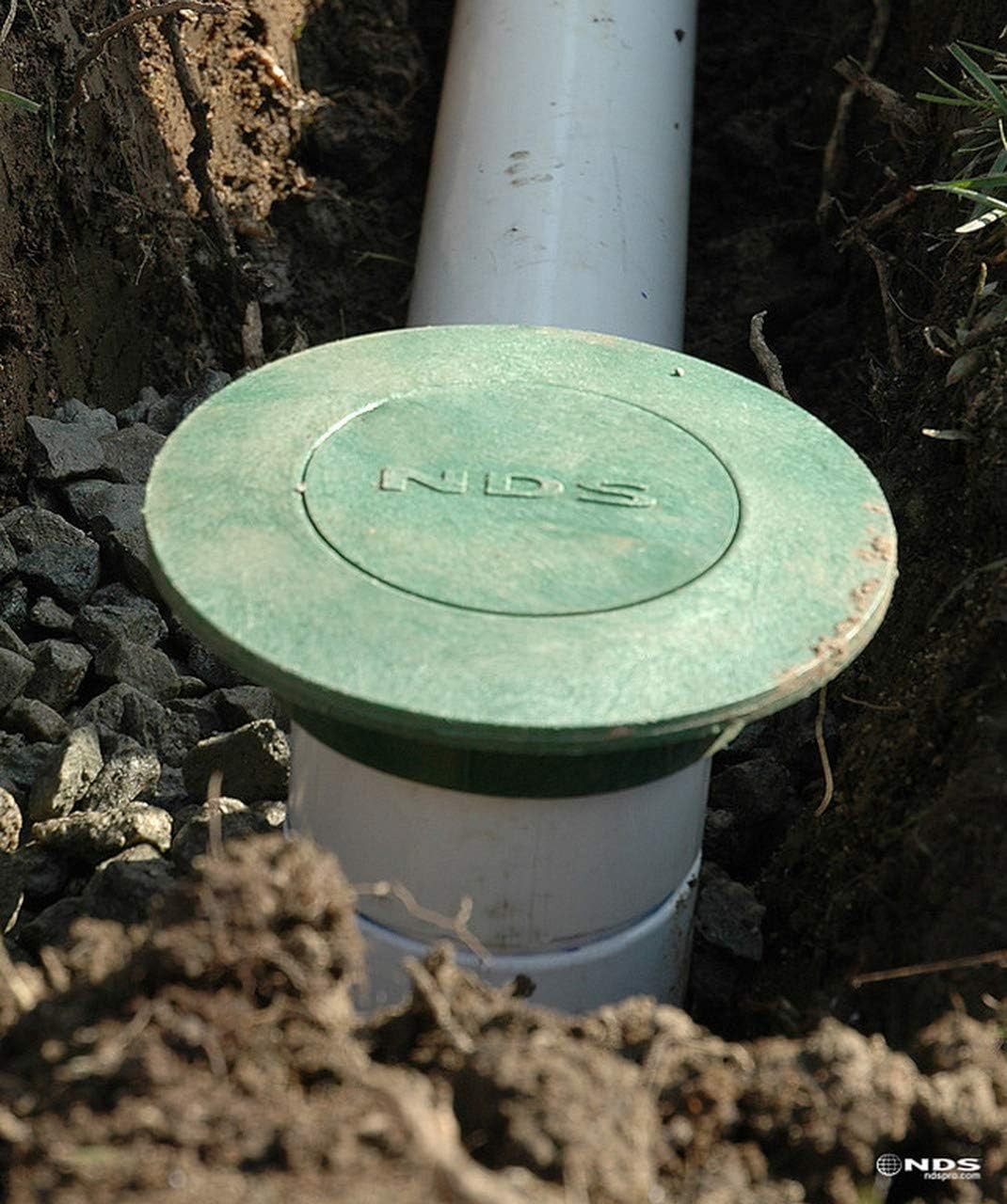 NDS 420 Pop-Up Drainage Emitter installed in the ground, connected to a white drainage pipe, surrounded by soil and gravel.