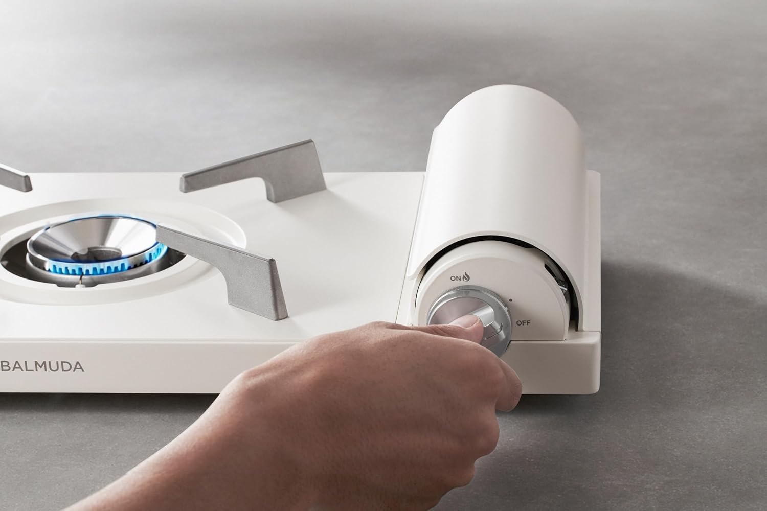 Hand adjusting the control knob of the BALMUDA TableStove KGS01JP-BK