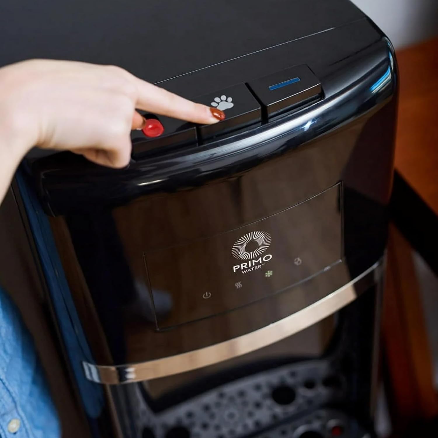 Hand pressing the pet paw button on the dispenser