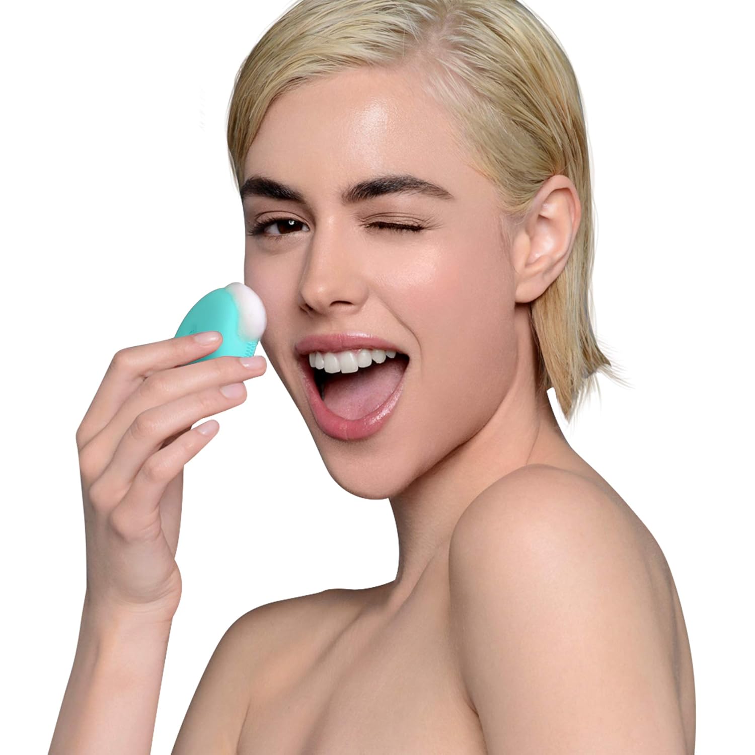 A woman smiling and using the FOREO LUNA play plus 2 to cleanse her cheek.