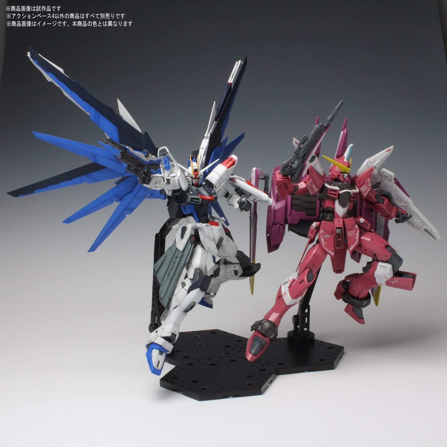 Two model kits displayed on separate Bandai Hobby Action Base 4 units.
