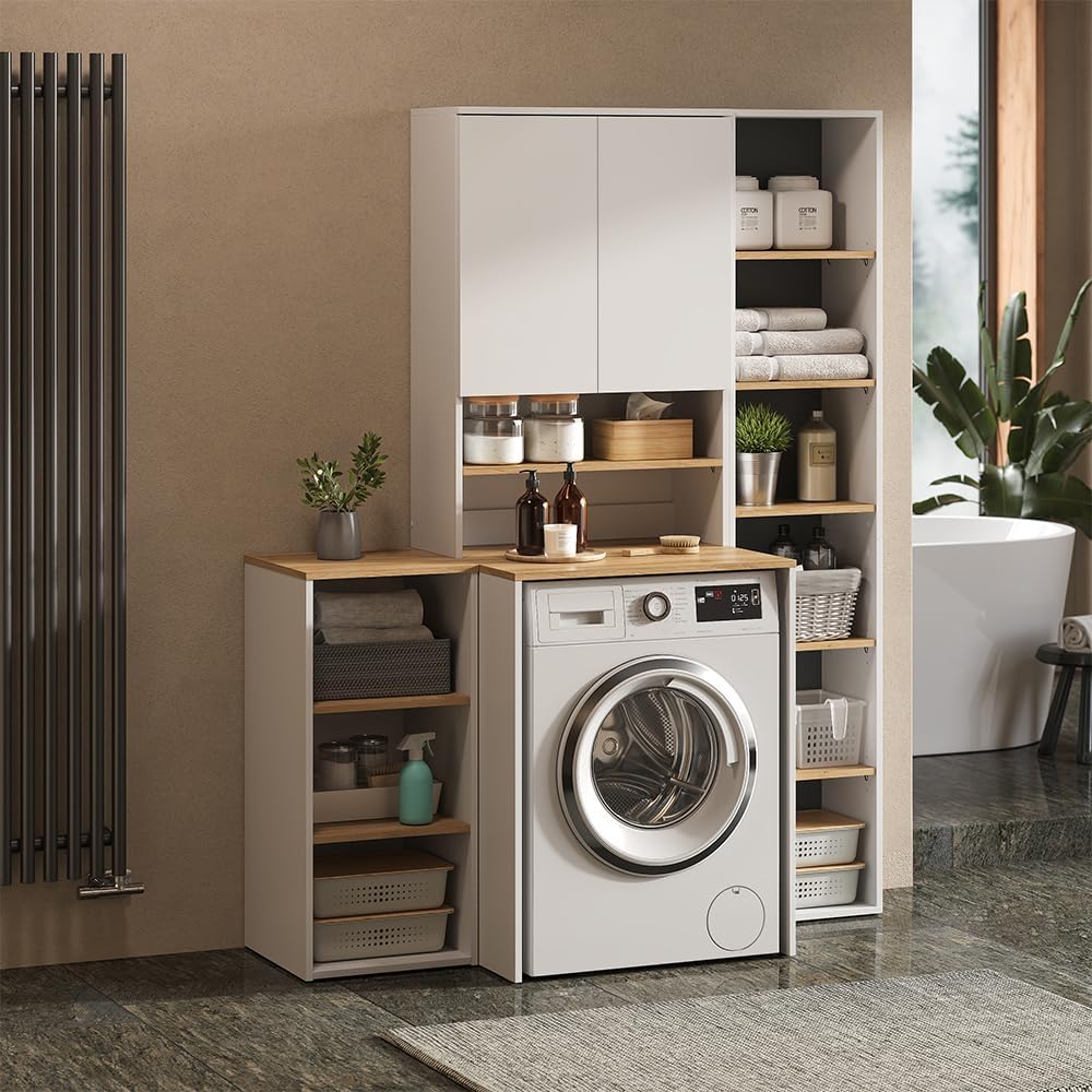 A modern laundry room setup featuring the Vicco Viktor washing machine cabinet integrated with other storage units, a washing machine, and decorative plants.