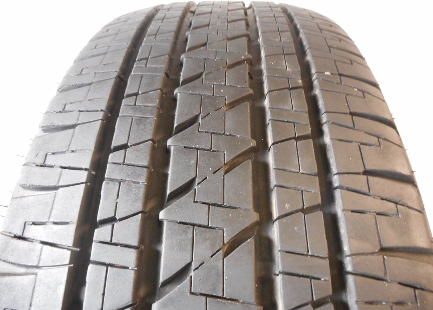 Primer pla view of the tread pattern on a Bridgestone Dueler H/L Alenza Plus tire.