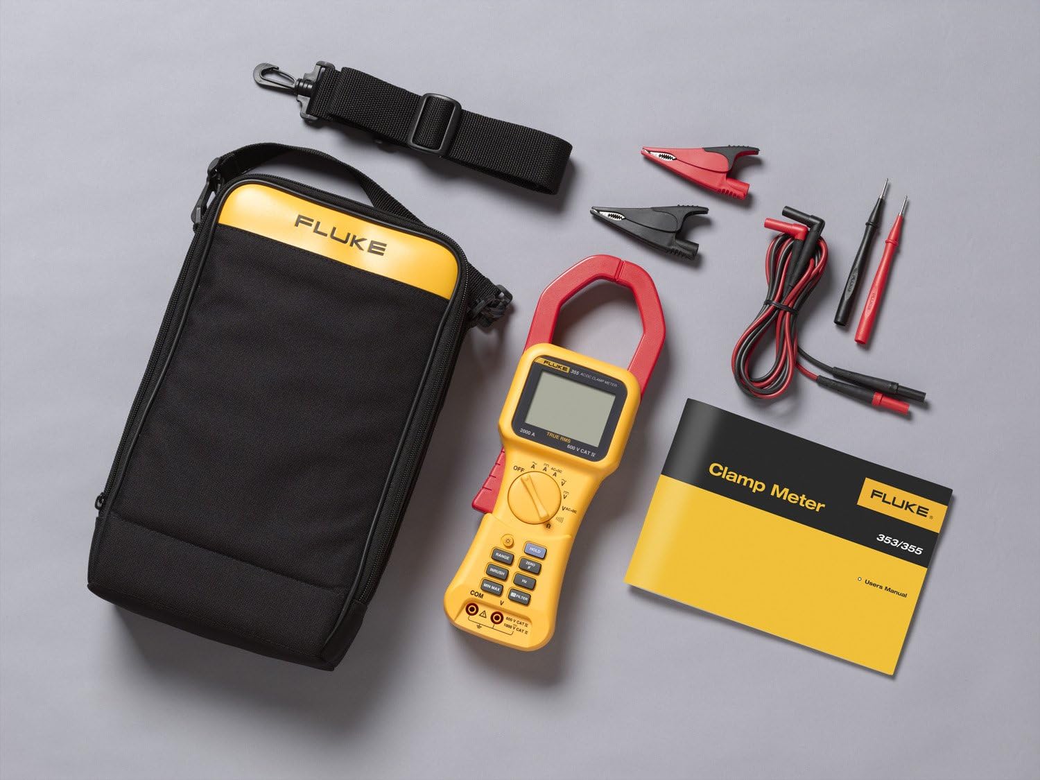 Contents of the Fluke 355 Clamp-Meter package laid out, including the meter, test leads, alligator clips, soft carrying case, and user manual.