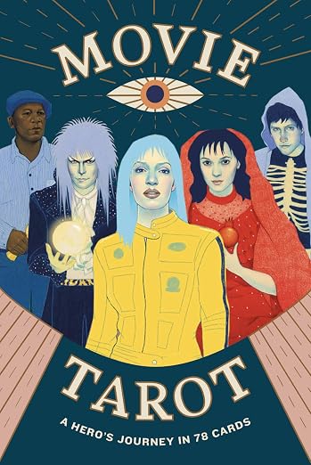 A eye with lines radiating out from it sits in the top center. There are five people in the frame. From left to right: a man wearing a blue shirt and blue jeans with a blue newsboy cap; a person holding a crystal ball with ball hair; a woman with blue hair wearing a yellow jacket; a dark haired woman wearing a red dress and holding a pomegranate; a boy wearing a light blue hoodie and a skeleton shirt.