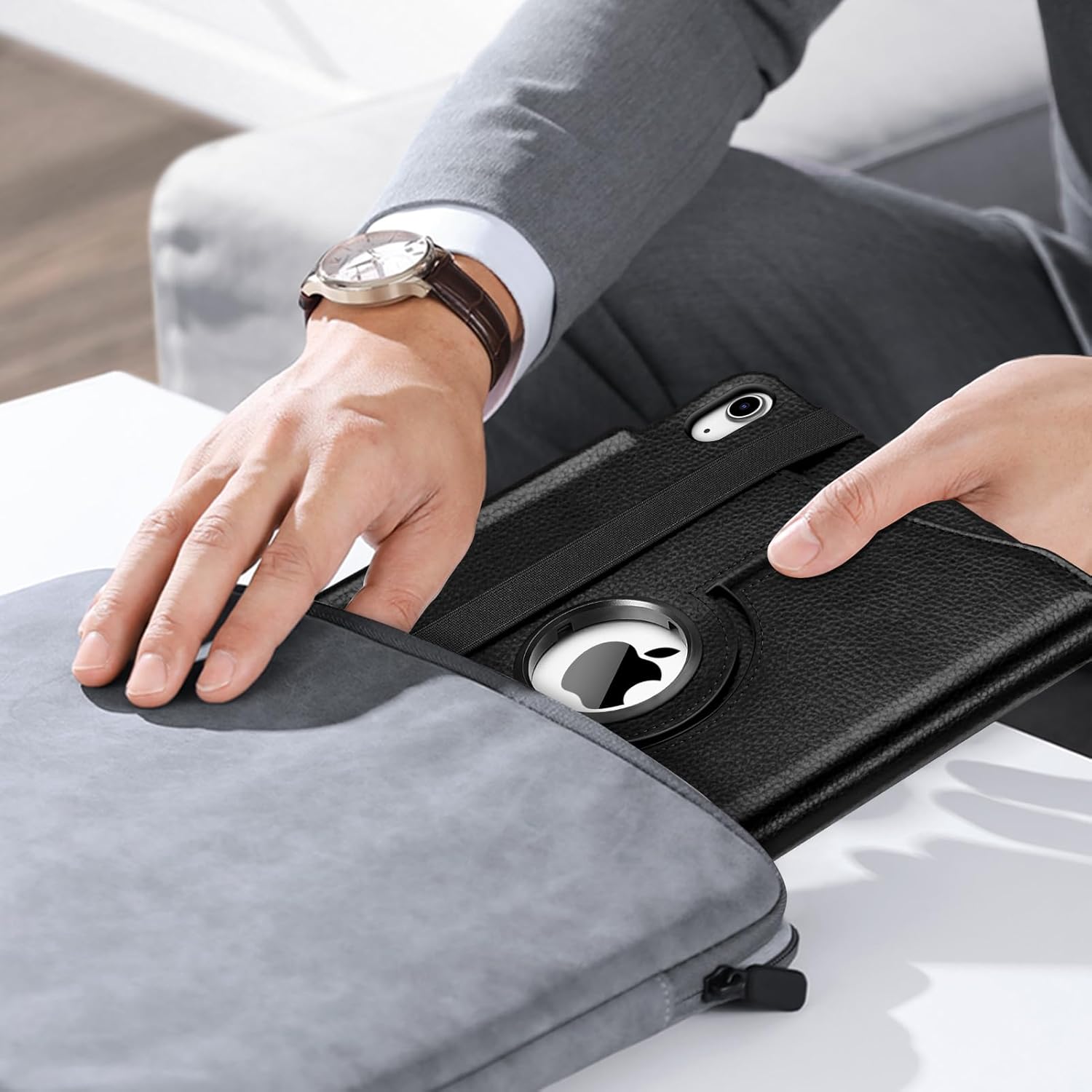 A person placing an iPad in the Fintie Rotating Case into a laptop bag, demonstrating the case's portability and secure closure.