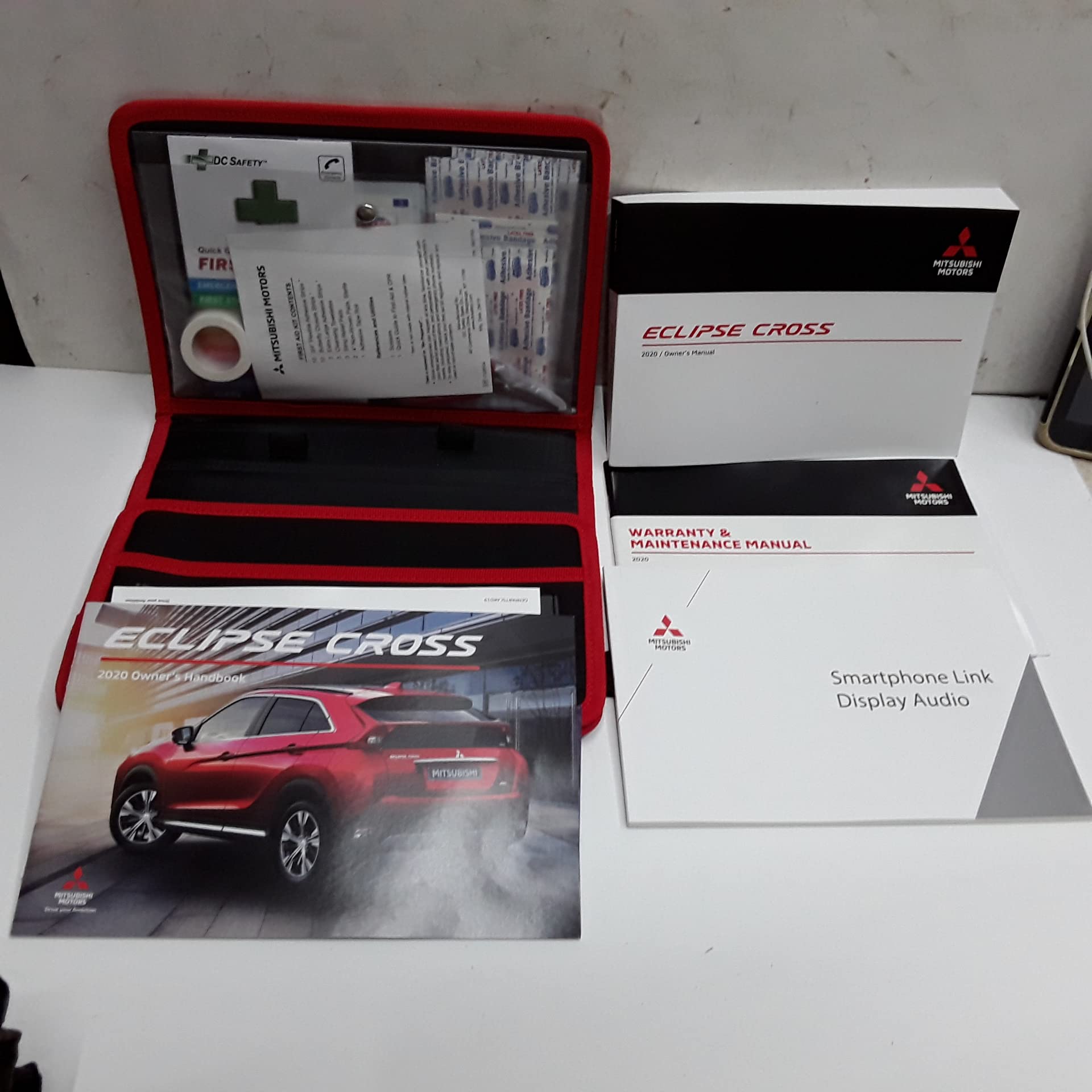 Collection of 2020 Mitsubishi Eclipse Cross manuals and a first aid kit