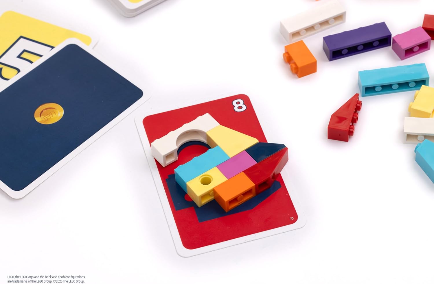A close-up of a LEGO model being built on a game card, with other cards nearby.