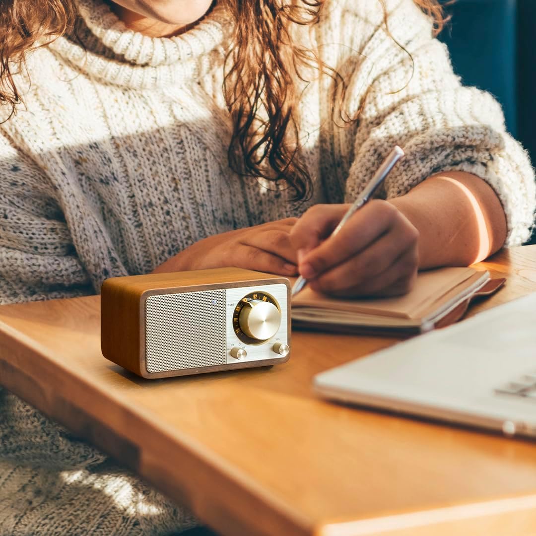 Person using Sangean WR-301 radio with a notebook