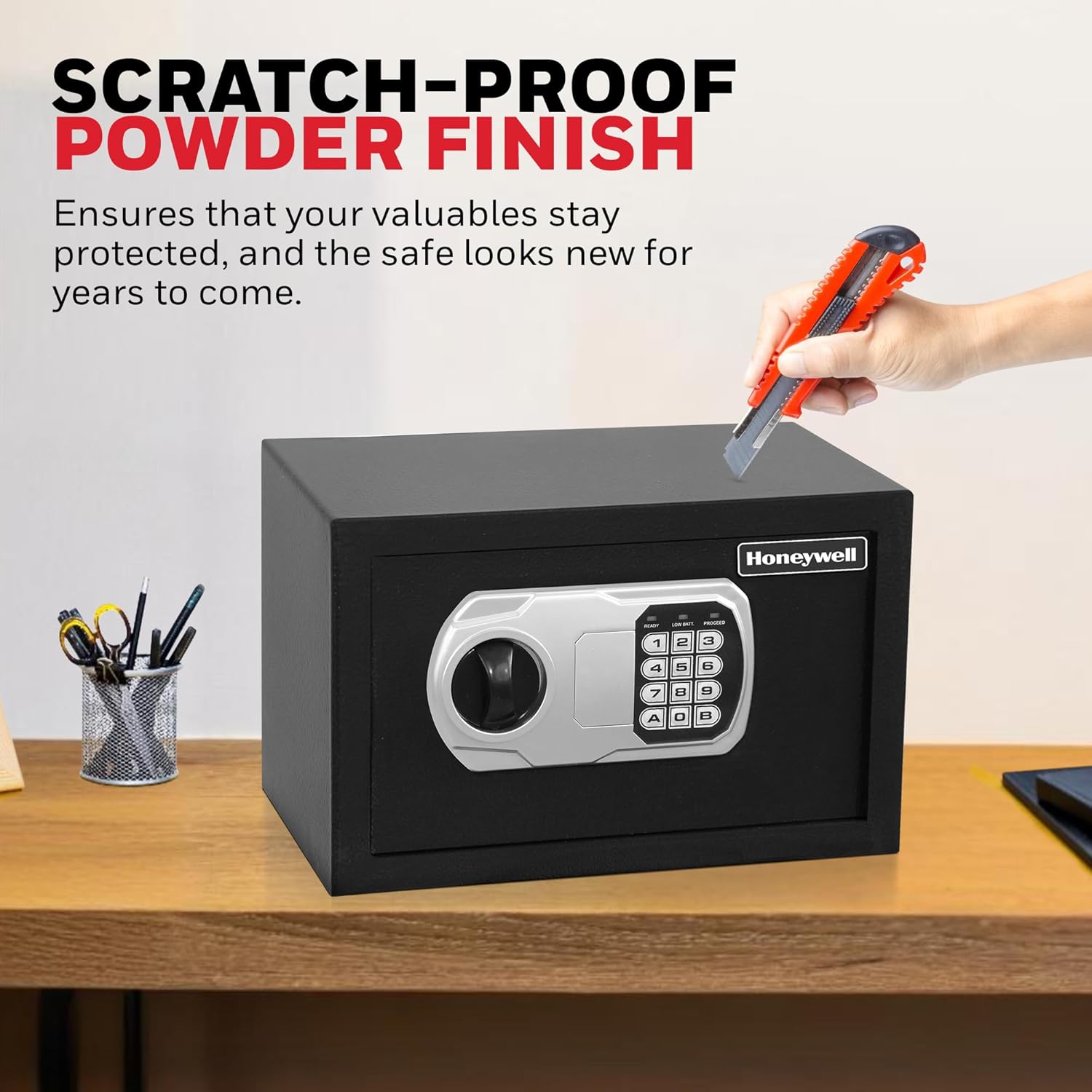 Hand holding a utility knife near the safe, demonstrating its scratch-proof powder finish.