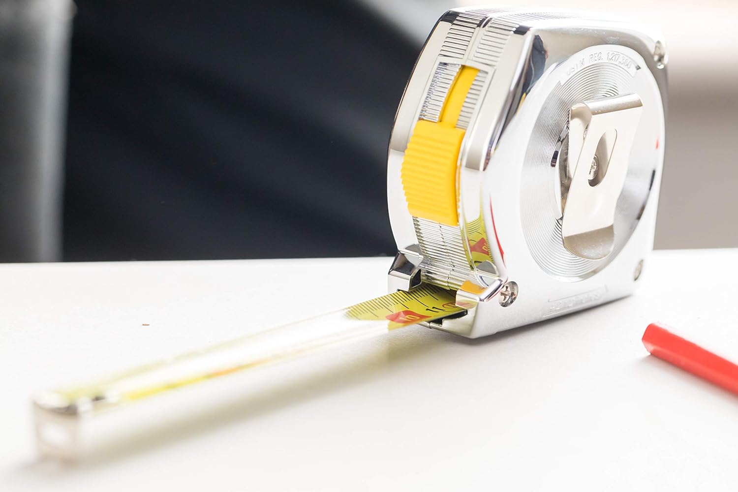 A person using the Stanley Powerlock 5m tape measure to take a vertical measurement on a wall