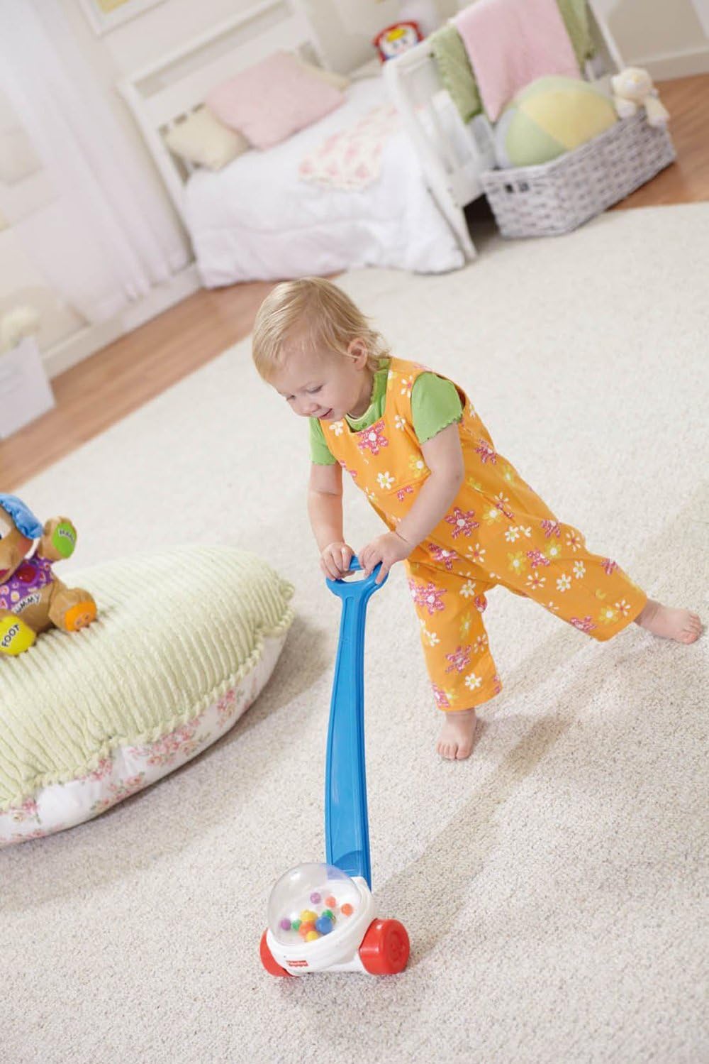 Toddler pushing the Fisher-Price Corn Popper on a carpeted floor.