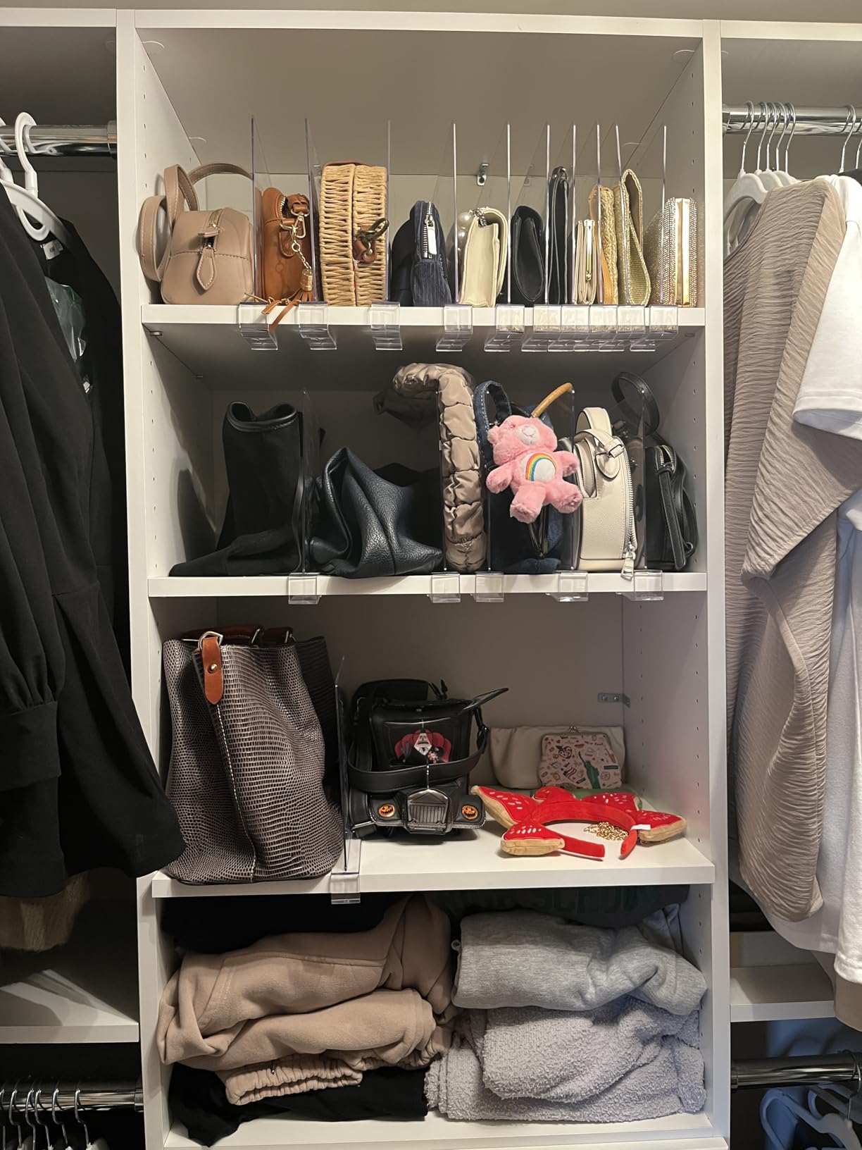 Clear acrylic shelf dividers separating handbags on a closet shelf
