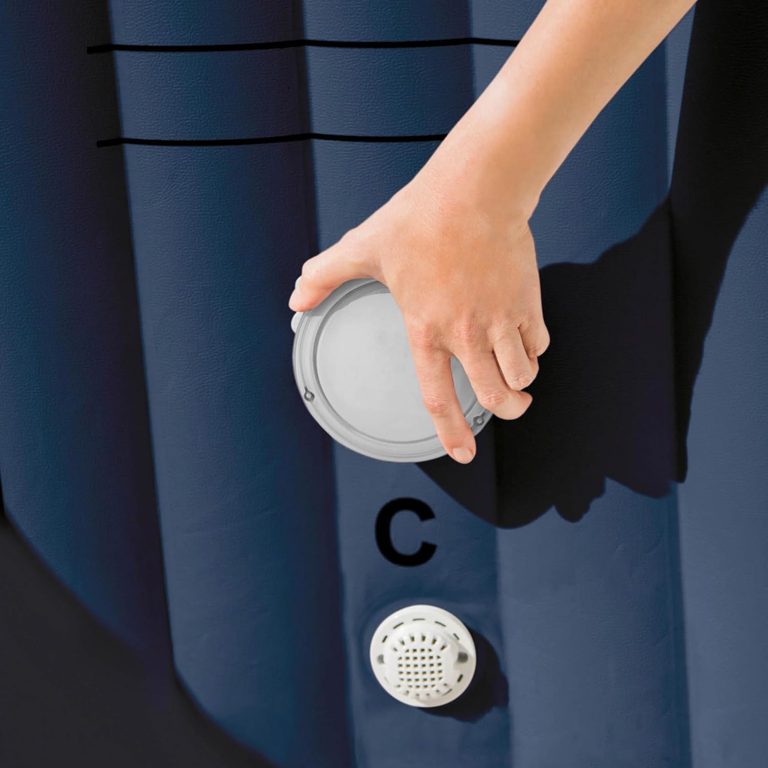 Hand placing Intex PureSpa LED Light into spa