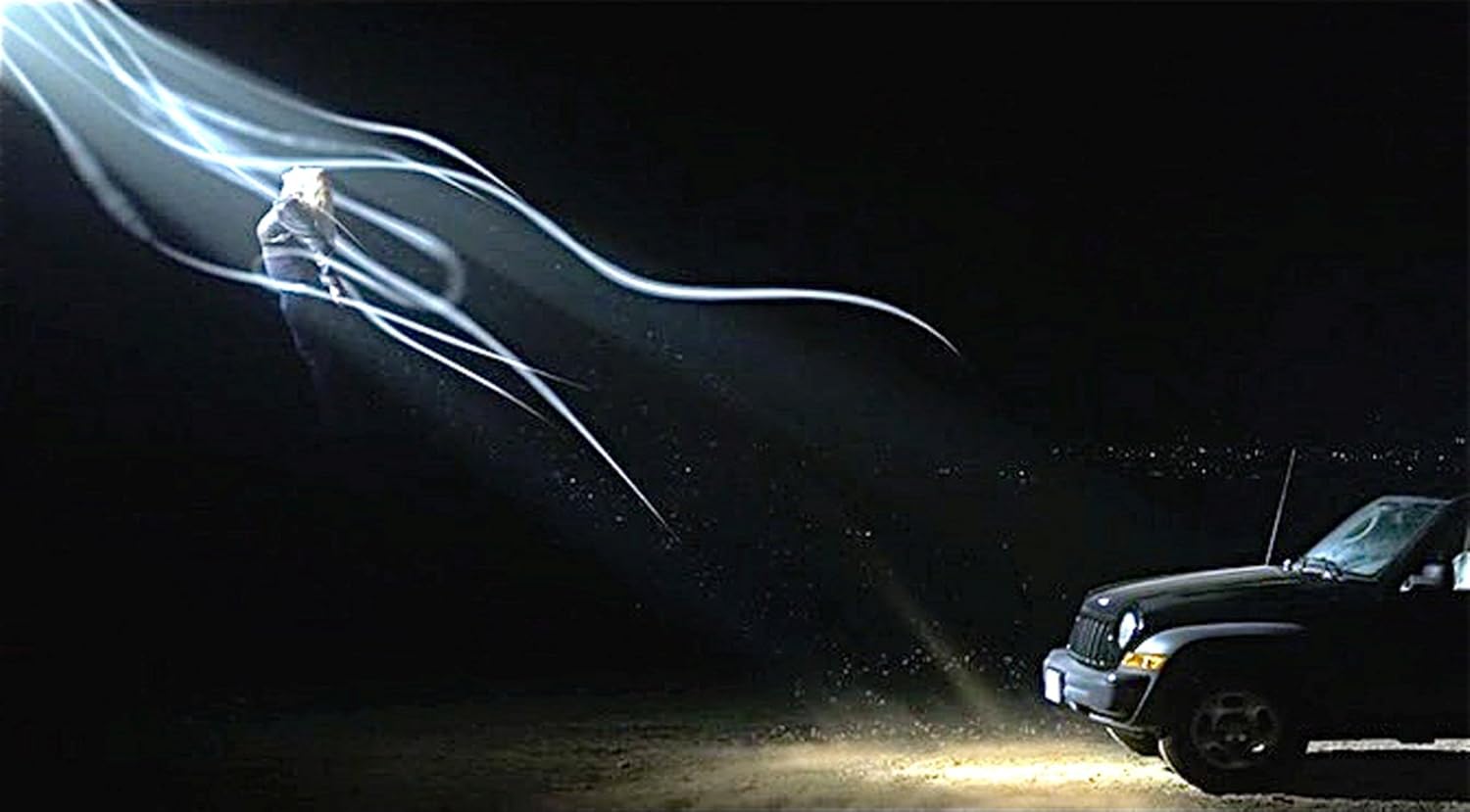 Still from Dark Alien movie showing a character in a dark setting with light streaks