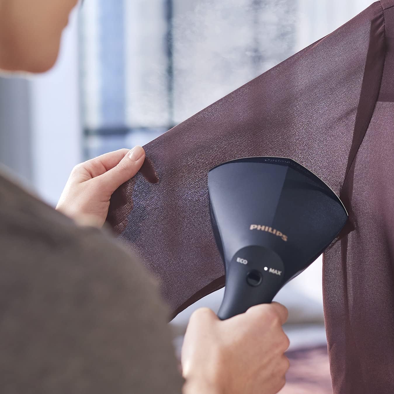 Person steaming a garment sleeve with Philips GC810/20
