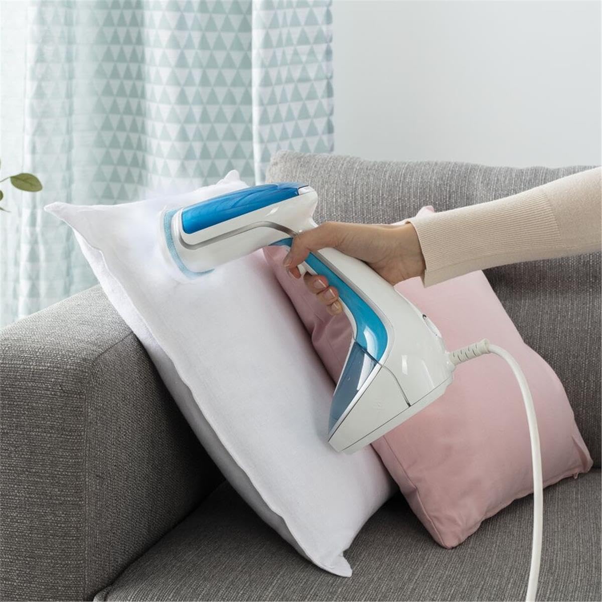 User steaming a pillow with Tefal Pure Tex Garment Steamer