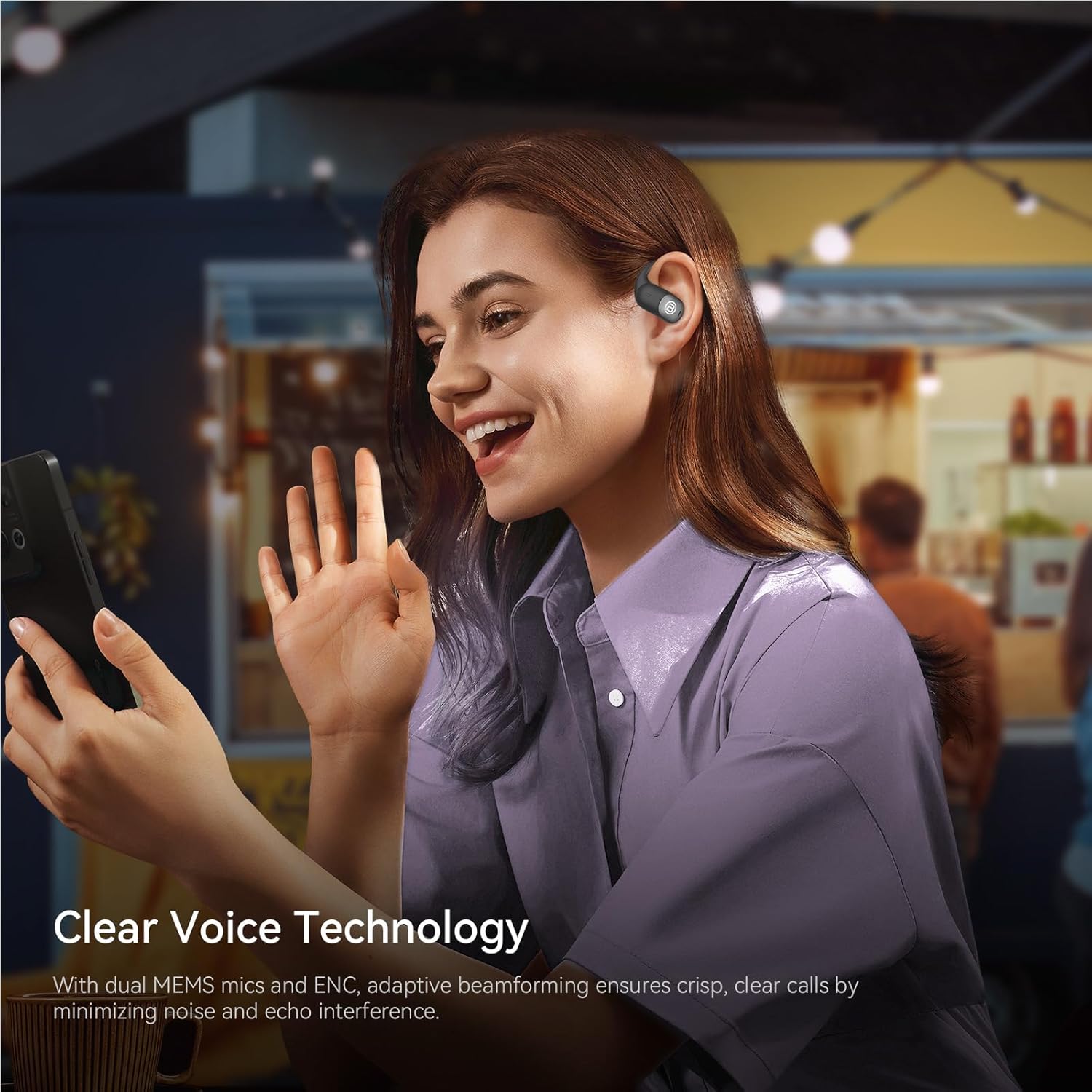 A person smiling and talking on a phone while wearing a BUGANI earbud, illustrating the clear voice technology for calls.