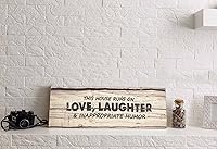 Vista 3 de Decoración de pared con citas en lienzo estirado, con texto en inglés This House Runs On Love, Laughter & Inappropriate Humor Cartel artístico