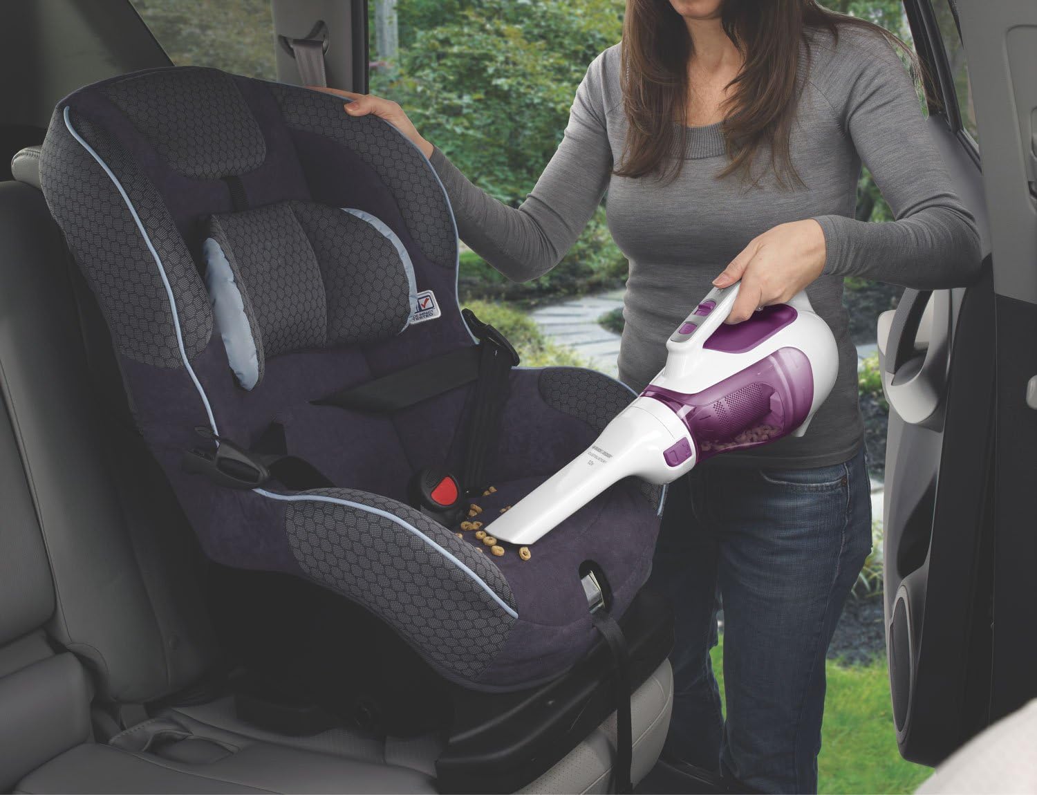 Person using the BLACK+DECKER CHV1210 Dustbuster to clean crumbs from a child's car seat.