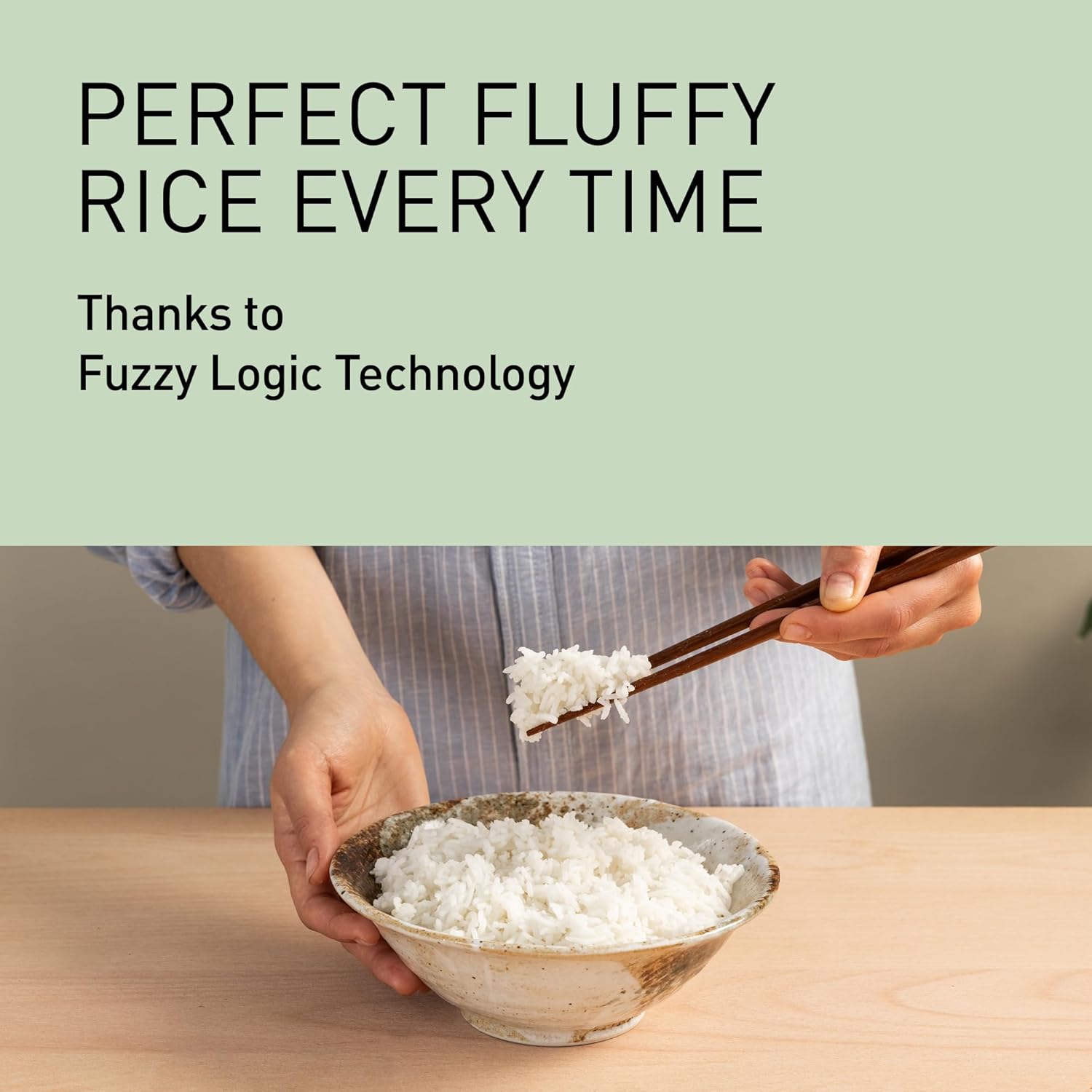 A person holding a bowl of perfectly cooked, fluffy white rice with chopsticks, illustrating the results of Fuzzy Logic Technology.