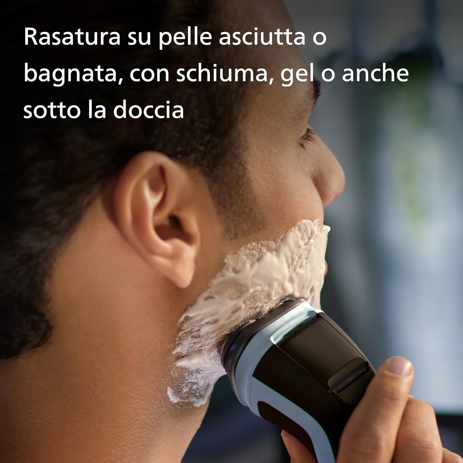 Man shaving with foam using a Philips electric shaver.