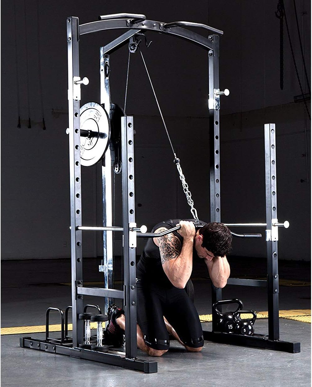 Man performing triceps pushdowns using the high pulley system of the power cage.