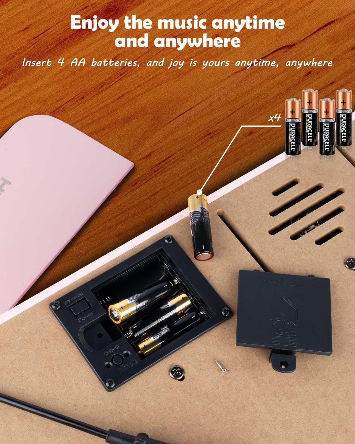 Battery compartment on the underside of the piano, showing 4 AA batteries being inserted.