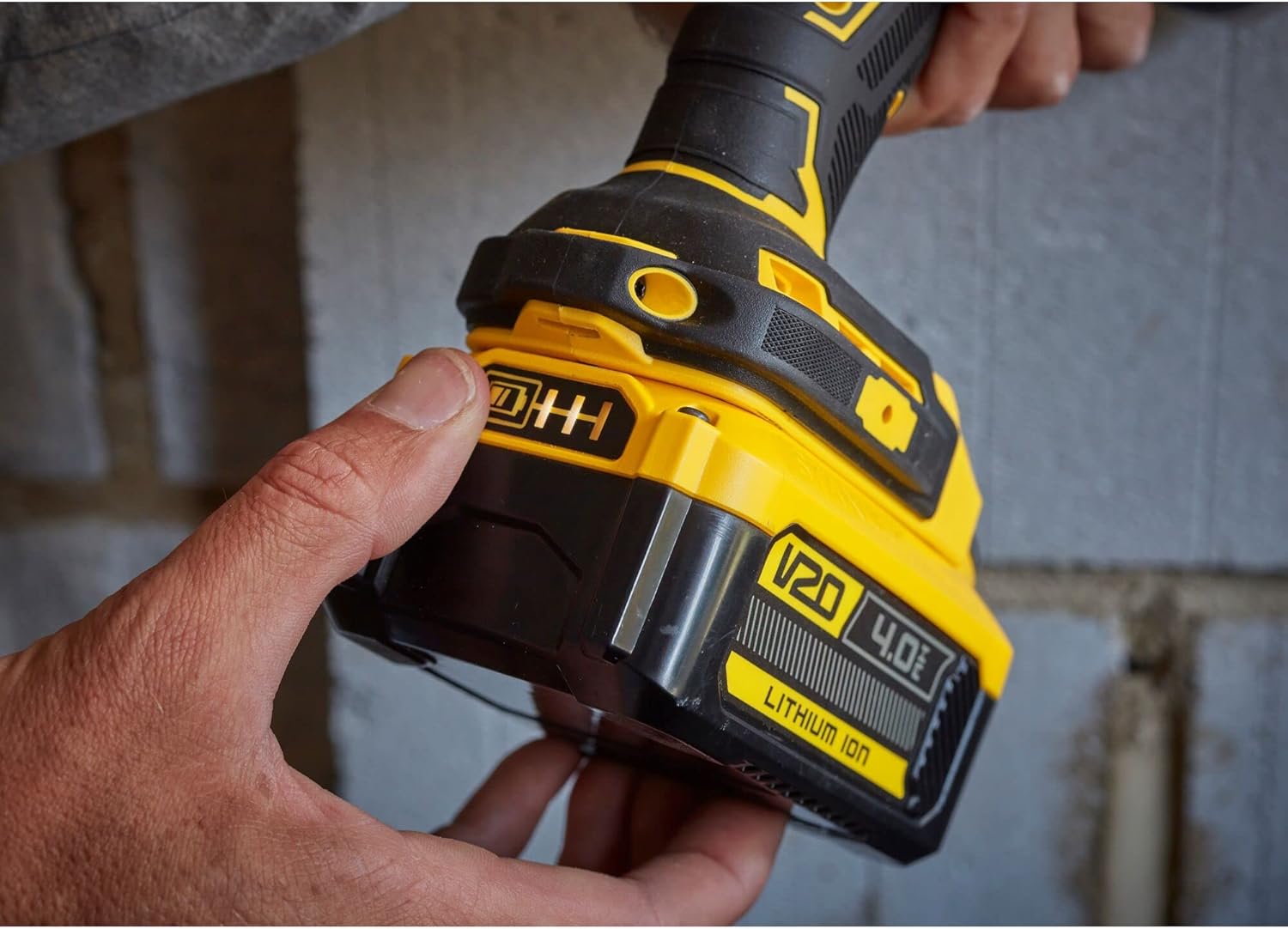 Hand inserting Stanley FATMAX V20 4Ah Lithium Ion Battery into a power tool.
