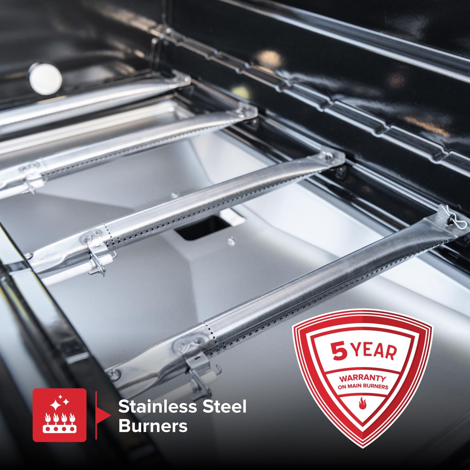 Close-up of stainless steel burners with a 5-year warranty badge