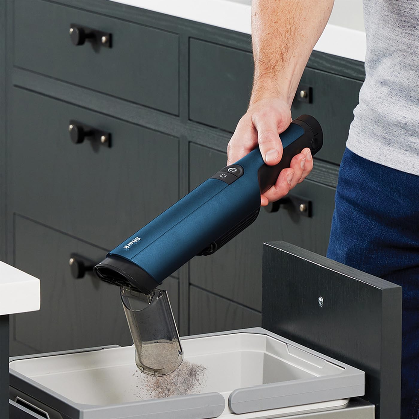 Shark WandVac 2.0 emptying dust cup into a trash bin