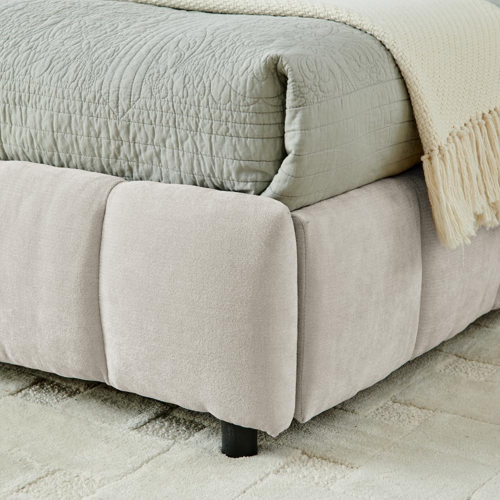 Close-up of the beige chenille upholstered fabric on the bed frame corner.
