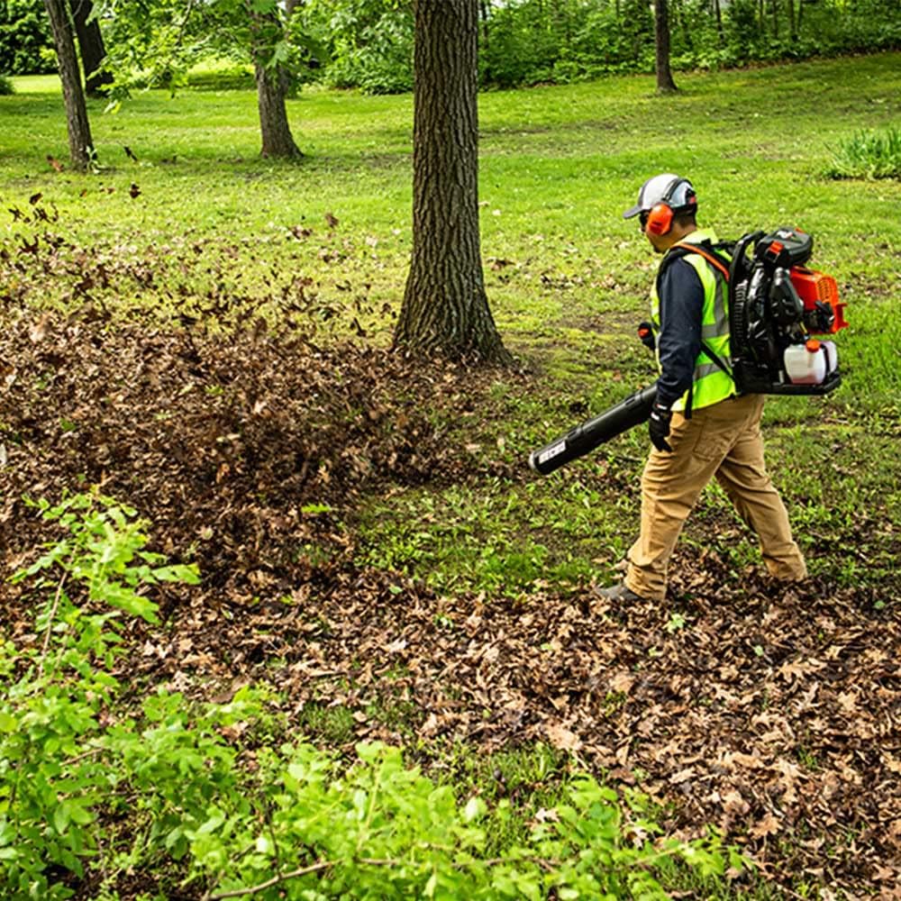 User operating ECHO PB-9010T Backpack Blower to clear leaves