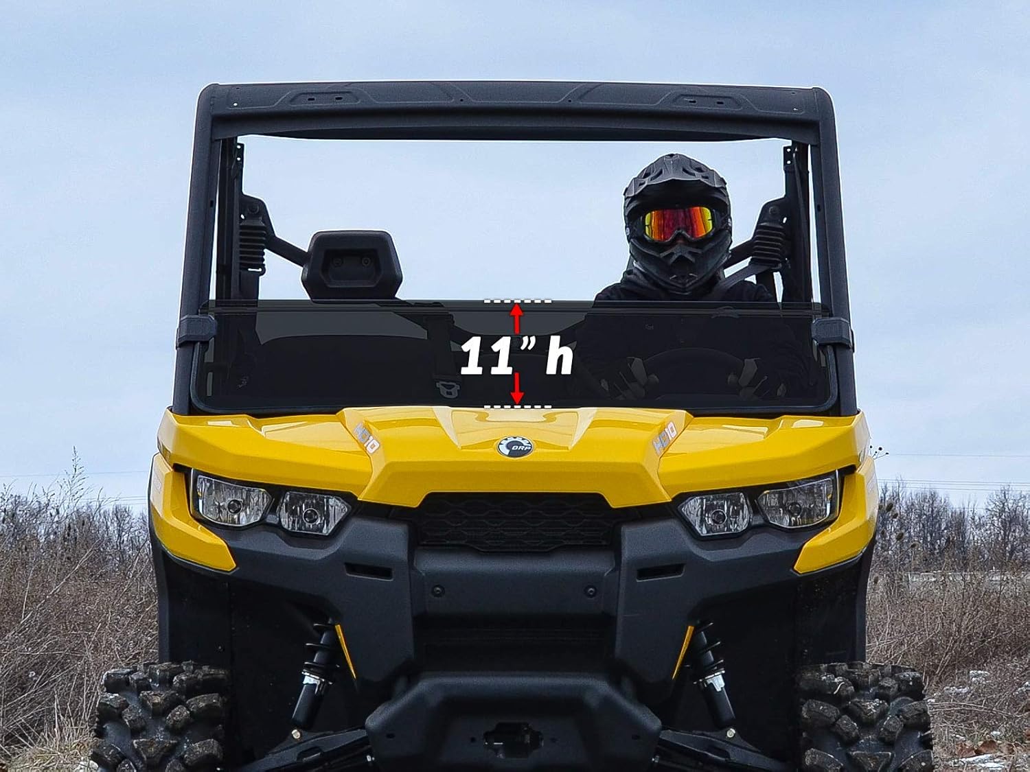 Front view of a yellow Can-Am Defender with the SuperATV Half Windshield installed, showing its 11-inch height.