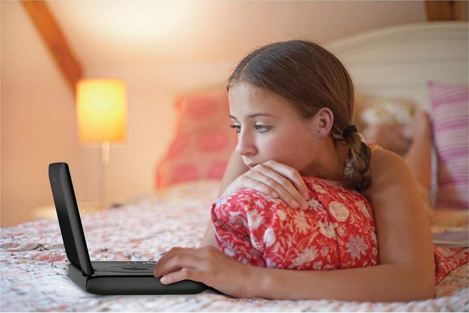 Girl watching DVD player in bed