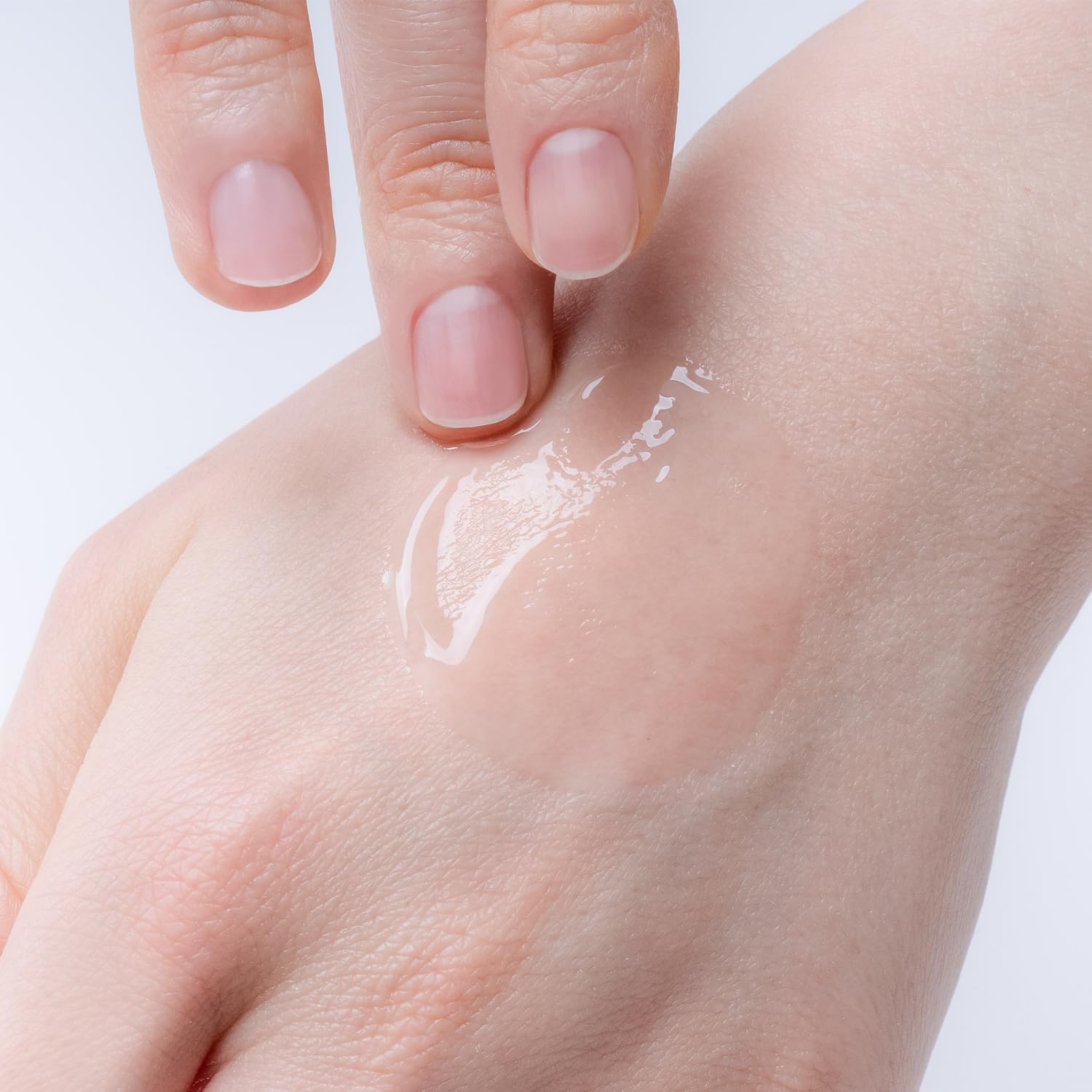 手の甲に伸ばされた透明感のあるジェル状の液体の画像