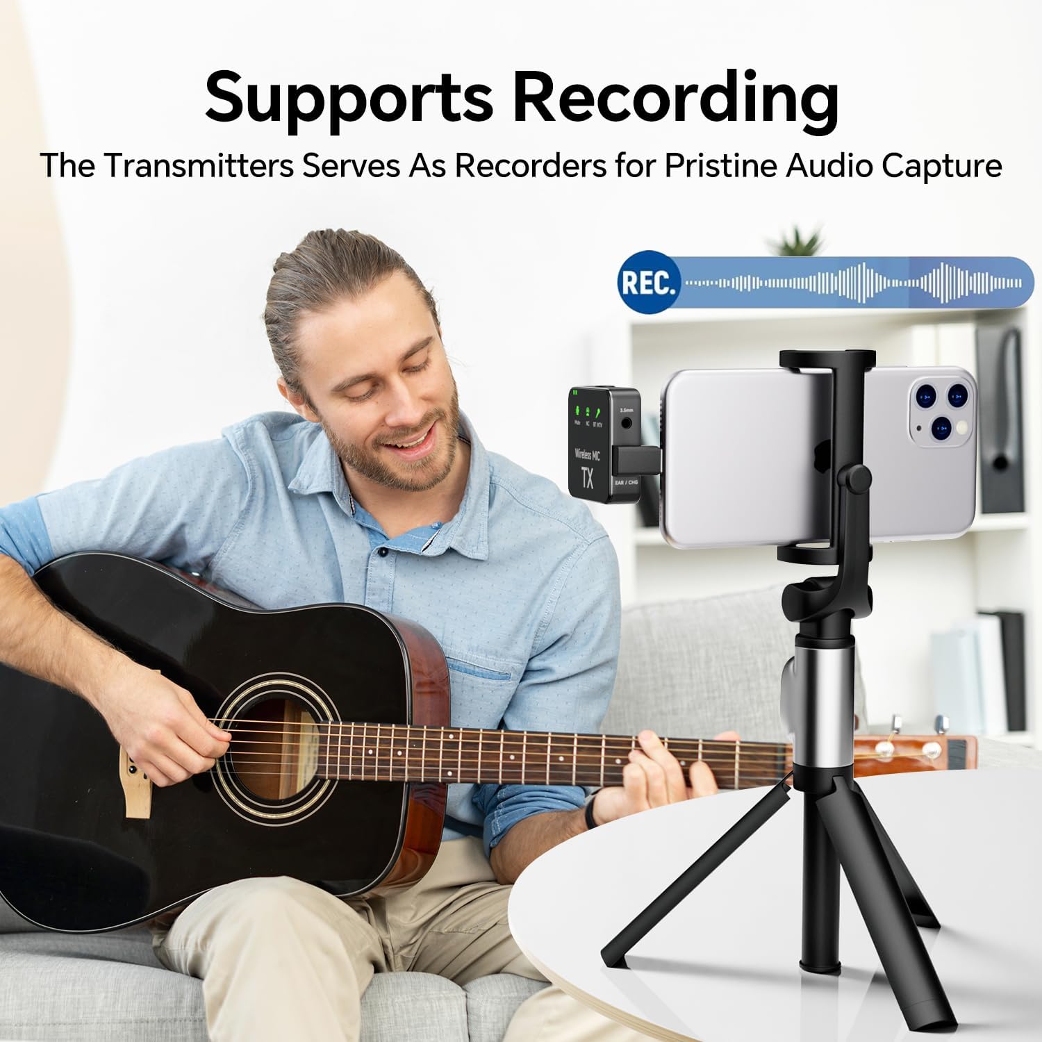 Man playing guitar with microphone connected to smartphone for recording