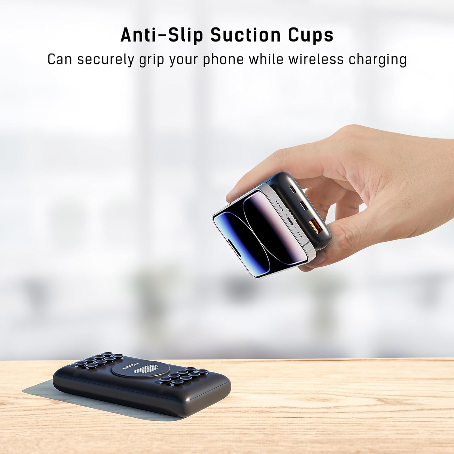 Hand holding a phone attached to the power bank via suction cups