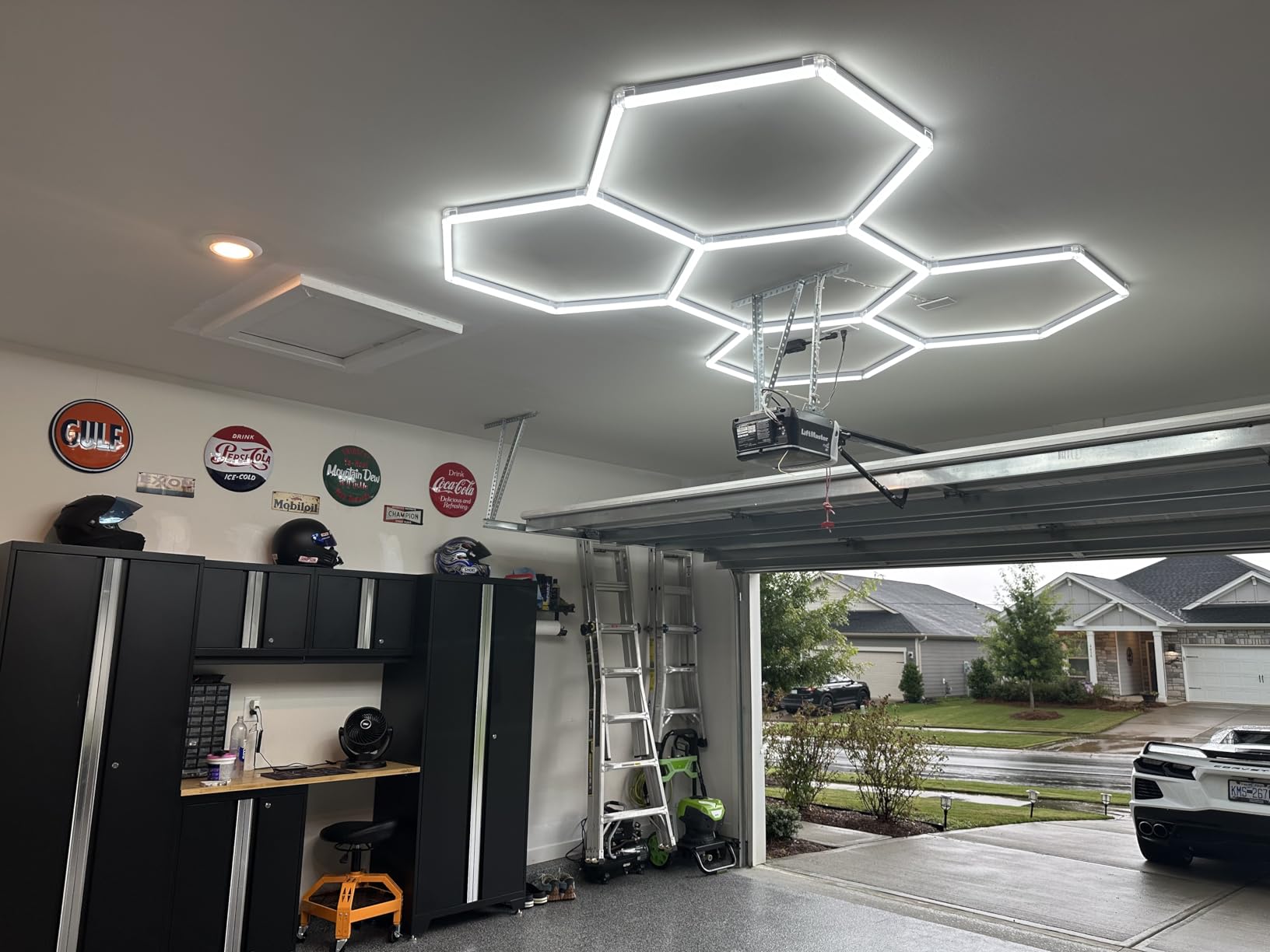 LED hexagon lights in a garage workshop illuminating workbench and storage cabinets