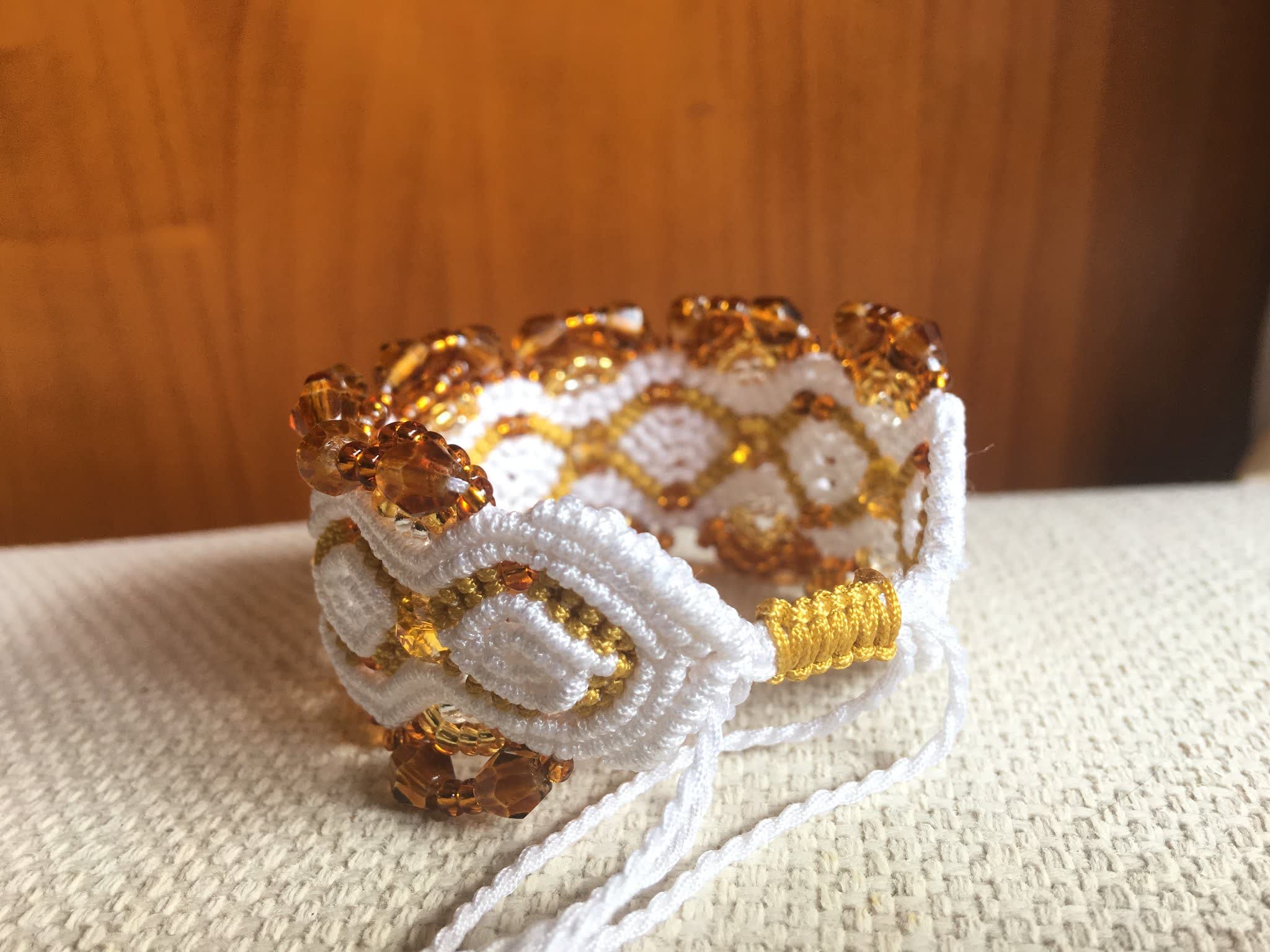 Pulsera macramé blanca y oro artesanal con cuentas cristal en tono ámbar en degradé, cierre ajustable