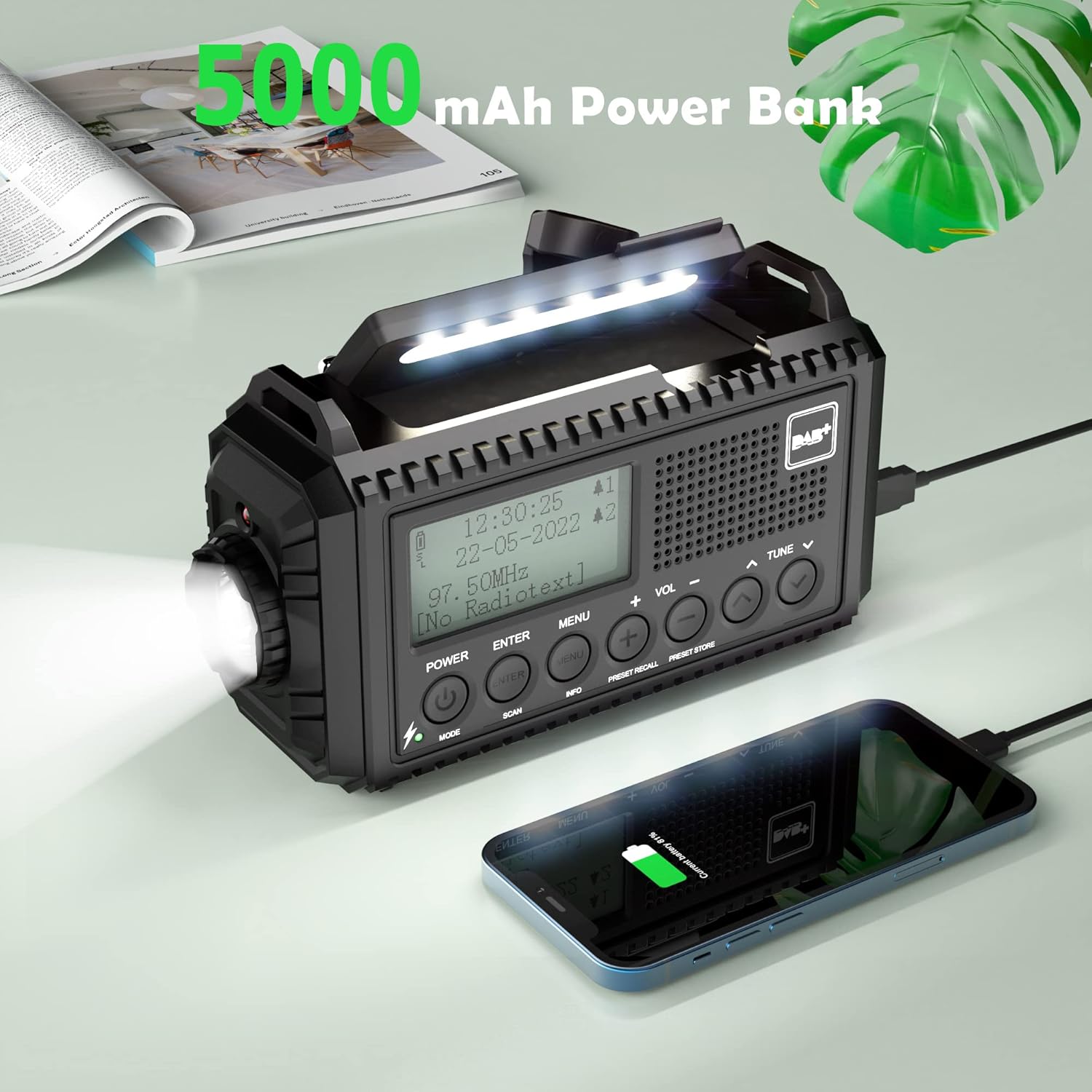 Mesqool CR1009Pro radio charging a smartphone via its USB output, highlighting its 5000mAh power bank capability.