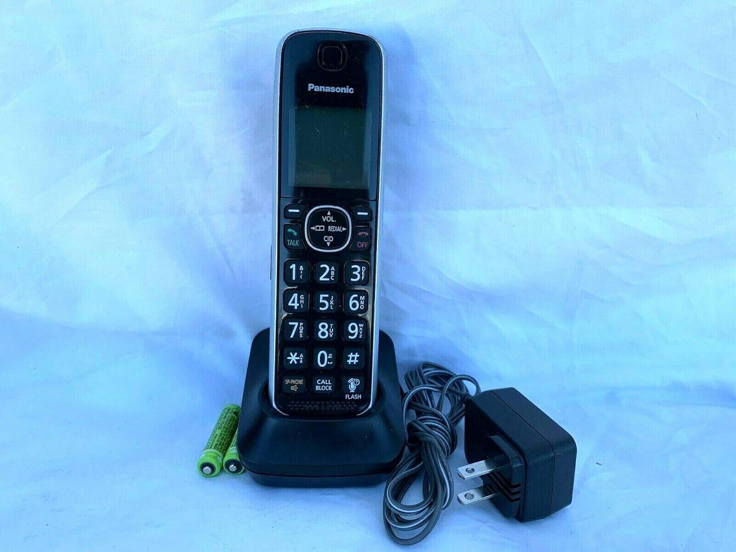 Front view of the KXTGFA61B cordless handset placed in its charging cradle, showing the display and keypad.